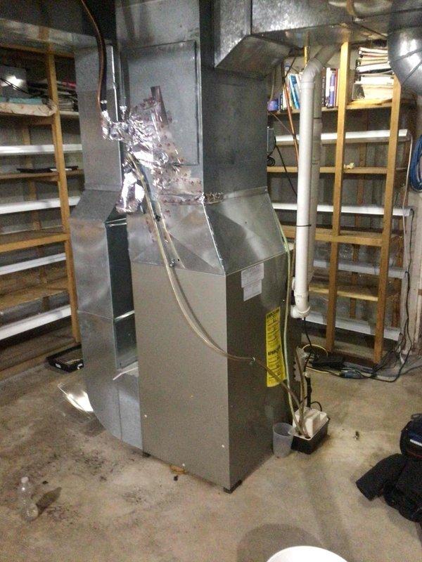 Performed diagnostic on 16-year-old heating system that was blowing cold air intermittently after resets. Inspection revealed improper combustion and upon removal of blower assembly, discovered water accumulation, darkening, evidence of rodent intrusion, and completely failed secondary heat exchanger. Equipment was tagged unsafe for operation and replacement options were provided to customer.