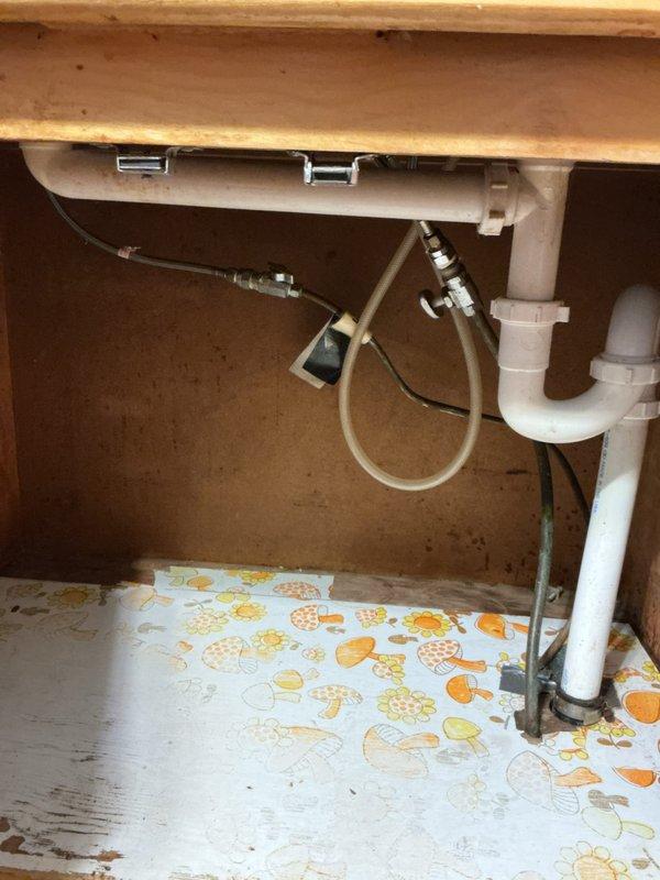 Successfully cleared severe clog in 135-year-old kitchen double sink drain system by dismantling the P-trap and removing accumulated debris. Inspected PVC plumbing configuration under sink for proper drainage function and reassembled all components, confirming complete water flow restoration with no leaks.
