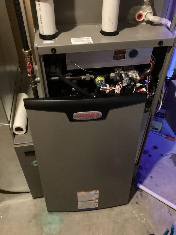 Responded to service call regarding water leakage from Lennox furnace. Diagnosed cracked collector box at the threaded drain connection point. Applied temporary repair with additional thread tape to minimize leaking until parts arrived. Upon return visit, removed damaged collector box, installed new replacement unit, reconnected condensate trap, and verified system operation. Confirmed no further leaks and proper furnace function after repair.