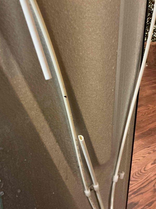 Responded to call for slow kitchen sink drain and requirement for ice maker line installation. Successfully cleared kitchen sink drain using auger and blow bag techniques to restore proper drainage. Installed new water line from supply to refrigerator for ice maker functionality, with proper mounting of PVC pipes along wall as documented in photos.