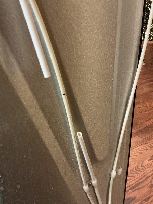 Responded to call for slow kitchen sink drain and requirement for ice maker line installation. Successfully cleared kitchen sink drain using auger and blow bag techniques to restore proper drainage. Installed new water line from supply to refrigerator for ice maker functionality, with proper mounting of PVC pipes along wall as documented in photos.