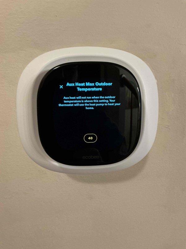 Responded to service call for one-year-old Carrier heat pump system with ecobee thermostat displaying "action required" notification. Diagnosed issue with auxiliary heat running unnecessarily due to improper temperature threshold configuration. Adjusted outdoor temperature setpoint from 70°F to 40°F to enable proper heat pump operation above 40°F, eliminating reliance on auxiliary heat during moderate temperatures. System now functioning correctly with appropriate staging sequence.