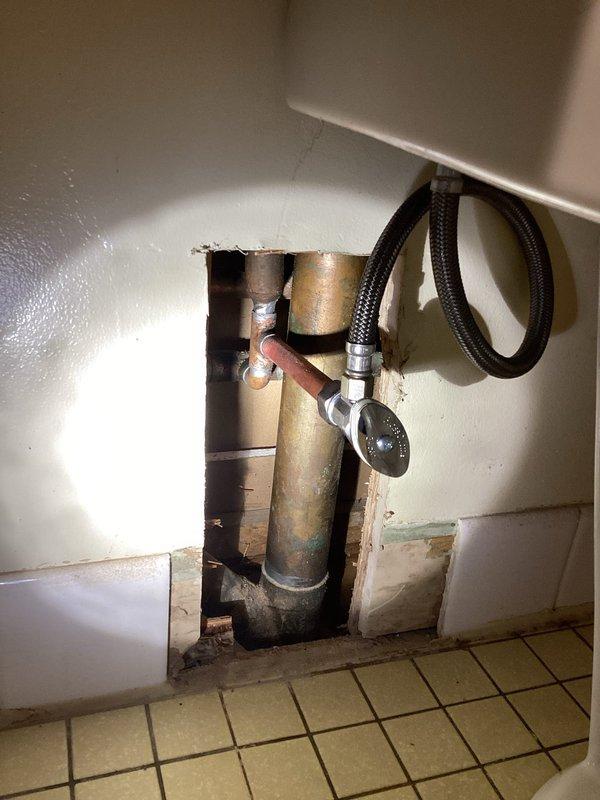 Accessed plumbing through wall cutout in modular home to replace toilet shutoff valves with chrome sleeve in upstairs bathroom. Installed new stops and supply tubes for main floor toilet and bath sink (copper tubing), along with new trip levers for both main floor and lower level toilets which customer had previously attempted to replace unsuccessfully.