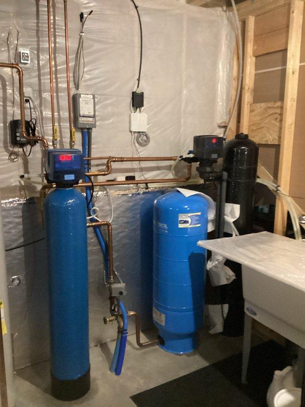 Responded to customer call regarding water softener leak. Upon inspection of residential water treatment system (water softener with digital control head, pressure tank, and filtration unit), no active leaks were observed. System was tested but leak issue could not be reproduced during service visit. Visual inspection showed components in good working condition with proper copper piping connections.