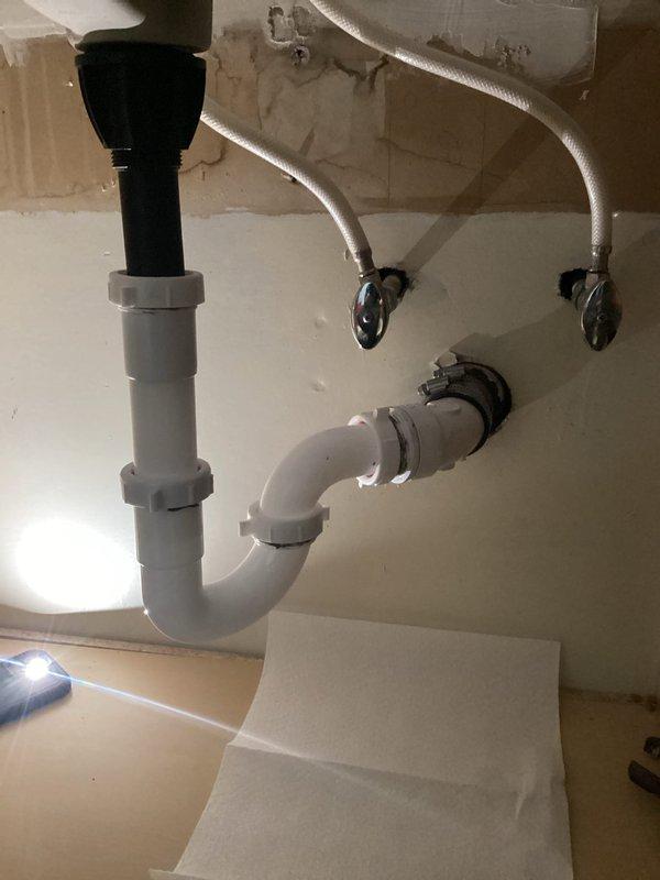 Successfully rebuilt vanity drain line, reconnecting all piping to the sink with new PVC P-trap assembly and verifying proper drainage after addressing the previously reported clog.