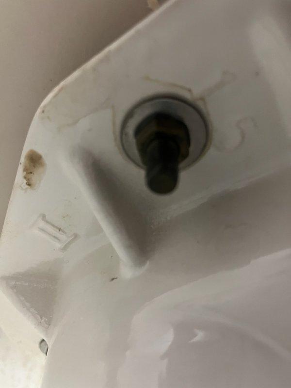 Responded to service call for toilet tank with slow leak. Upon inspection, found loose tank-to-bowl bolt nut causing seepage. Tightened bolt to resolve immediate leak issue. Noted toilet is approximately 20+ years old with visible corrosion on supply line connection. Provided customer with options for both repair and complete toilet replacement.