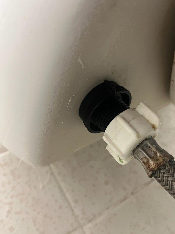 Responded to service call for toilet tank with slow leak. Upon inspection, found loose tank-to-bowl bolt nut causing seepage. Tightened bolt to resolve immediate leak issue. Noted toilet is approximately 20+ years old with visible corrosion on supply line connection. Provided customer with options for both repair and complete toilet replacement.