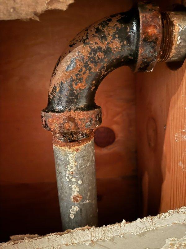 Responded to water leak complaint where galvanized kitchen drain pipe was leaking into basement bedroom ceiling. Inspection revealed severely corroded pipe joint with extensive ceiling water damage. Replaced damaged section of galvanized drain pipe as a temporary solution, noting that complete drain system replacement will be necessary in the future due to advanced deterioration.