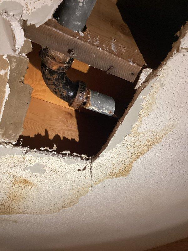Responded to water leak complaint where galvanized kitchen drain pipe was leaking into basement bedroom ceiling. Inspection revealed severely corroded pipe joint with extensive ceiling water damage. Replaced damaged section of galvanized drain pipe as a temporary solution, noting that complete drain system replacement will be necessary in the future due to advanced deterioration.