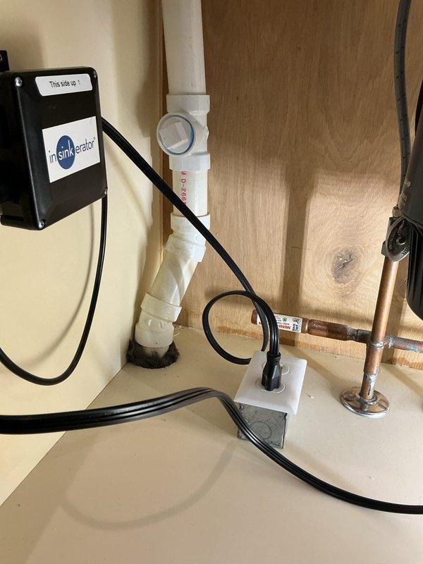 Successfully reinstalled kitchen sink plumbing following countertop replacement, including new faucet installation, InSinkErator garbage disposal installation, and reconfiguration of drain lines with PVC piping to ensure proper drainage.