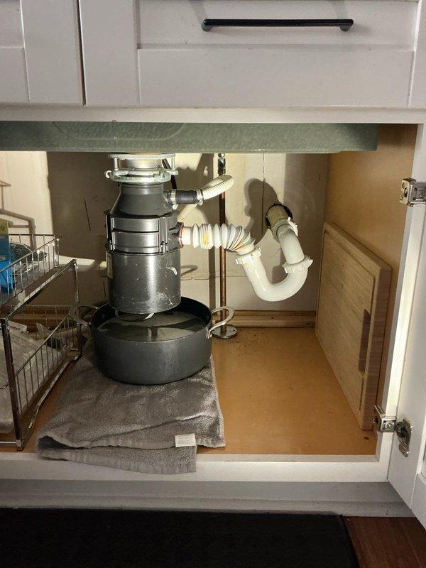 Responded to customer complaint of garbage disposal leaking from disposal unit with drain positioned too high. Removed faulty garbage disposal, installed new drain basket and outlet tee to correct drainage configuration. Completed installation of updated plumbing assembly with proper P-trap configuration to ensure proper function and eliminate leakage.