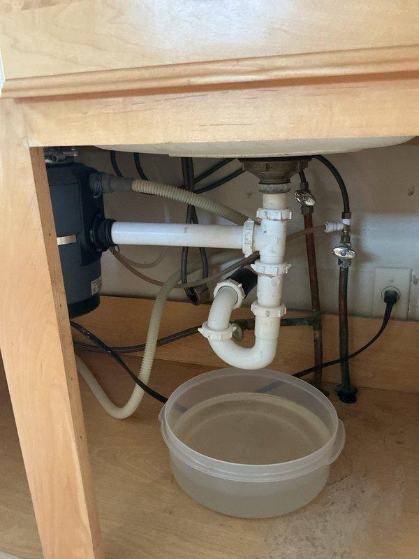 Responded to kitchen sink clogging issue. Inspected under-sink plumbing system and found water accumulation in catch basin below P-trap. Performed drain service and offered snaking procedure; recommended hydro-jetting for more comprehensive clearing of the drainage system to prevent future blockages.