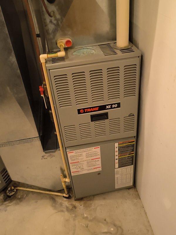 Diagnosed and serviced a Trane XE 90 furnace (20+ years old) that was blowing cold air with a flashing code. Found a loose electrical harness which was secured to restore heat function temporarily. Identified crack in heat exchanger requiring replacement. Customer scheduled for complete furnace and AC replacement quote as the AC unit had also failed in fall.