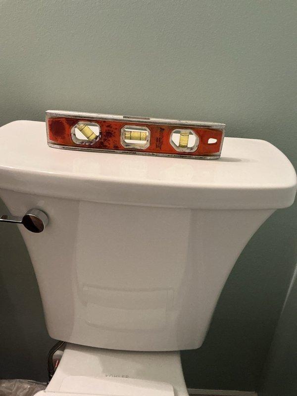 Responded to a callback regarding a toilet with an unlevel tank from previous installation. Issue verified using spirit level. Tank position adjusted and properly leveled to ensure correct operation and aesthetic appearance of the fixture.