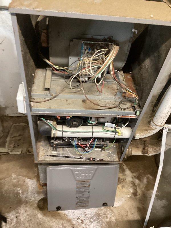 Inspected inoperative furnace in dairy facility service room that had been unused since spring. Diagnostic examination revealed multiple critical failures: non-functioning blower motor, damaged blower wheel, and faulty control board. Documentation and photos were submitted for replacement estimate due to the extensive repairs needed and overall poor condition of the unit.