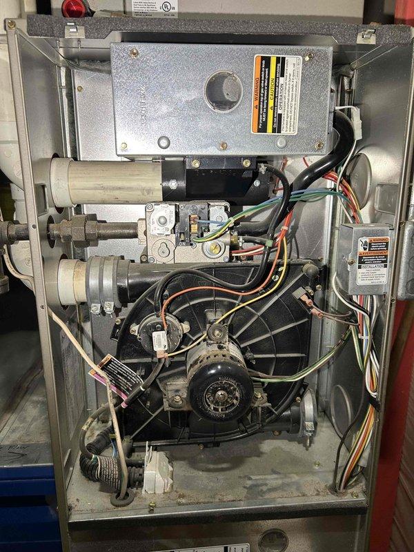 Performed comprehensive furnace tune-up on aging unit. Adjusted gas train pressure from 3.94 inWC to 3.40 inWC and cleared accumulated debris from condensate drain line and trap. Verified proper operation of all major components including inducer motor, capacitor, pressure switch, control board connections, and thermostat; noted moderate filter condition and advised homeowner about white soot buildup on secondary heat exchanger, recommending filter replacement and dust removal.