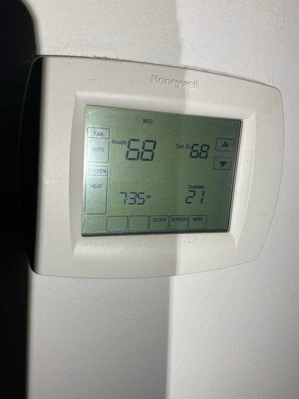 Performed furnace tune-up on a 17-year-old natural gas regulator that was improperly installed for an LP gas single-stage furnace serving three zones. Inspected the heat exchanger and condenser coils, noting debris accumulation requiring cleaning. Examined the Honeywell digital thermostat which was functioning properly with correct temperature readings. Customer indicated limited interest in full system replacement at this time.