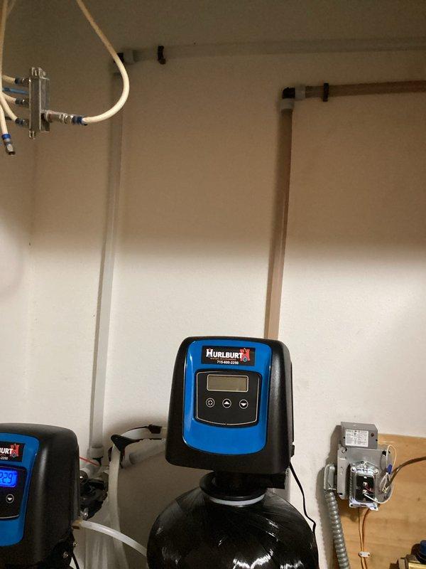 Responded to customer concern regarding previously installed carbon filter causing skin issues, black residue in toilets, and foul odors in laundry. Inspection of TOTO toilet revealed significant mineral deposits and discoloration inside tank. Examined Hurlburt water treatment system and determined bypass of carbon filter was necessary. Successfully bypassed carbon filter to address customer's water quality complaints.