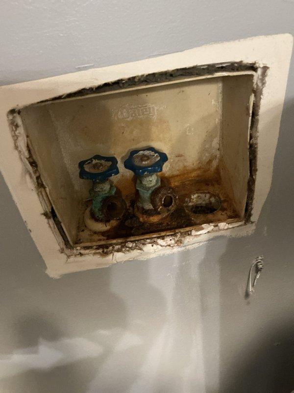 Responded to service call for two plumbing issues: replaced corroded washing machine valves and installed a new toilet. The original toilet (approximately 40 years old) had stopped running properly and required water shut-off. Completed installation of new laundry valves to address deterioration and corrosion observed in the recessed water valve access panel. Customer advised about clearance issue with toilet tank lid due to overhead shelf.
