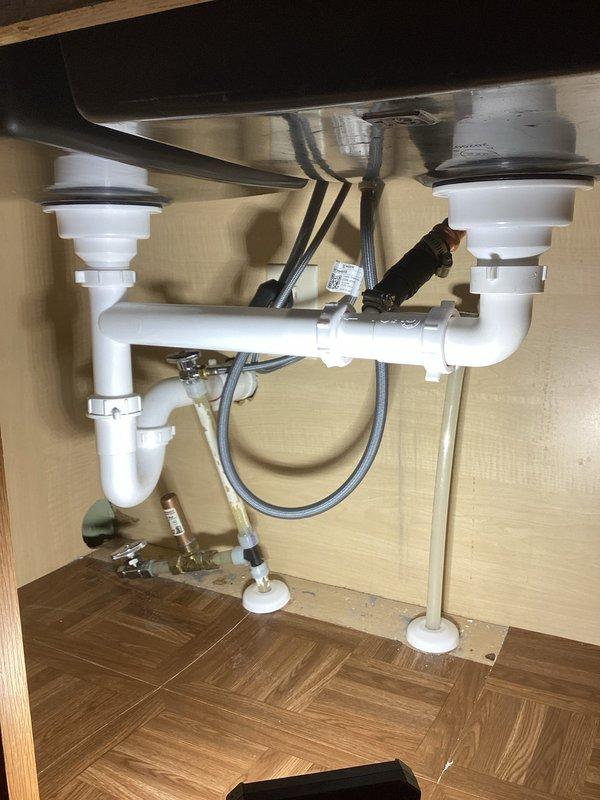 Installed customer-supplied kitchen faucet on existing marble top sink, replacing all undersink plumbing components. Replaced three shut-off valves that were not closing properly and installed new drain piping assembly for dual-basin sink, ensuring proper function of both basins and new fixtures.