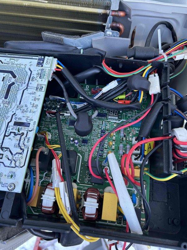 Diagnosed communication failure on garage mini-split system displaying E1 error code between indoor and outdoor units. Inspection revealed non-functioning outdoor main board with no LED indicators despite verified power supply. Documented stripped main ground wire terminal. Initiated parts procurement process for replacement main board to restore system functionality.