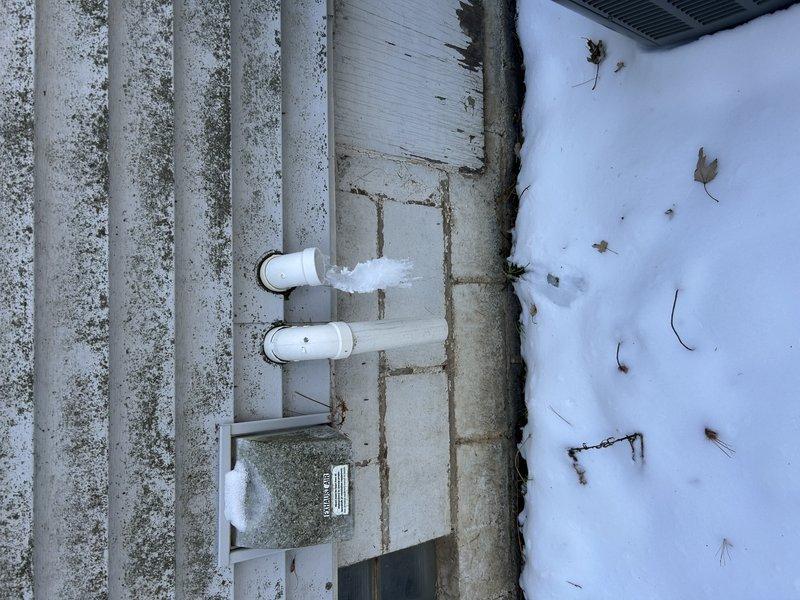 Diagnosed and repaired no heat condition on recently installed furnace. Found two issues: improperly pitched exhaust piping was corrected by cutting and re-gluing with proper slope back to unit, and cleared blockage in condensate drain system that had caused inducer motor to fill with water. Restored proper drainage and verified normal heating operation after repairs.