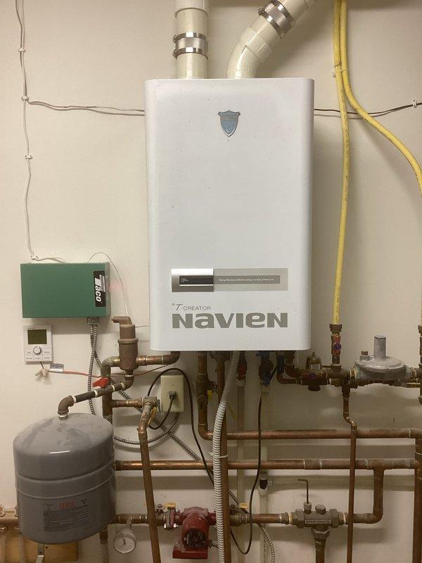 Responded to service call for Navien boiler displaying error code E13. Diagnostic testing revealed internal circulation pump failure due to faulty control board not outputting required 120V to pump. Adjusted dampers in the chiropractic section to address overheating issues. Submitted parts request for replacement control board, noting potential availability concerns due to unit age. Customer informed that new boiler installation may be necessary if parts are unavailable.