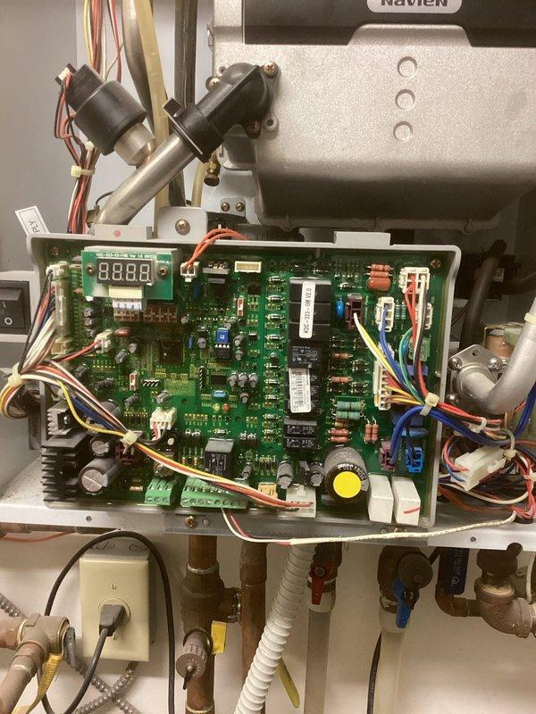 Responded to service call for Navien boiler displaying error code E13. Diagnostic testing revealed internal circulation pump failure due to faulty control board not outputting required 120V to pump. Adjusted dampers in the chiropractic section to address overheating issues. Submitted parts request for replacement control board, noting potential availability concerns due to unit age. Customer informed that new boiler installation may be necessary if parts are unavailable.