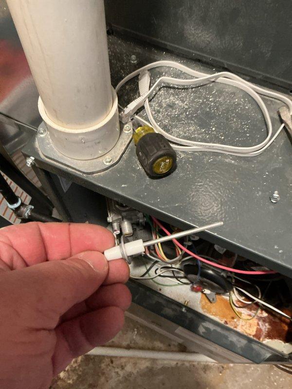 Responded to no heat complaint on 5-year-old Goodman furnace. Diagnostic inspection revealed furnace attempting to ignite (clicking) but failing to maintain flame. Identified corroded flame sensor and signs of rust in cabinet, though no active leaks were present. Successfully replaced flame sensor, restoring normal heating function.