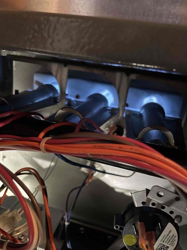 Diagnosed inoperative furnace showing inducer operation but unlit status lights. Found control board relay was buzzing loudly with failing contacts. Temporarily restored operation by tapping relays, but recommended replacement of the control board due to faulty relay. Customer informed that system replacement would be more cost-effective given the unit's age (15 years) and recent repair history. Photos documented the Emerson circuit board with failing Zettler relays and burner assembly inspection.