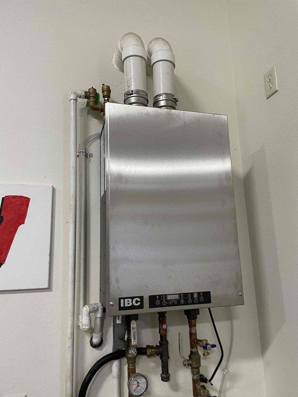 Diagnosed ignition failure on IBC boiler serving shop heating system. Verified spark igniter functioning properly but identified faulty gas valve preventing fuel flow. Temporarily restored operation by manually actuating solenoid during ignition sequence. Completed parts order form for replacement gas valve after confirming unit is out of warranty.