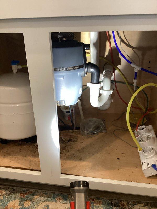 Removed faulty leaking garbage disposal from kitchen sink as requested by customer. Reconfigured plumbing with PVC P-trap assembly to establish standard drain connection. Installation includes new drain strainer basket in stainless steel sink, eliminating the disposal system entirely while maintaining proper drainage functionality.