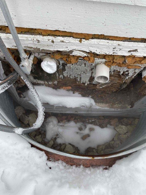 Responded to no-heat call for furnace that had been serviced previously. Diagnosed high pressure switch failure due to frozen intake pipe. Found exhaust and intake pipes terminating improperly in window well with missing elbow that customer had removed during summer renovation. Installed 12" pipe section with proper elbow configuration to prevent flue gas recirculation and intake freezing. Verified restored differential pressure readings and confirmed furnace now operating correctly with proper heat output.