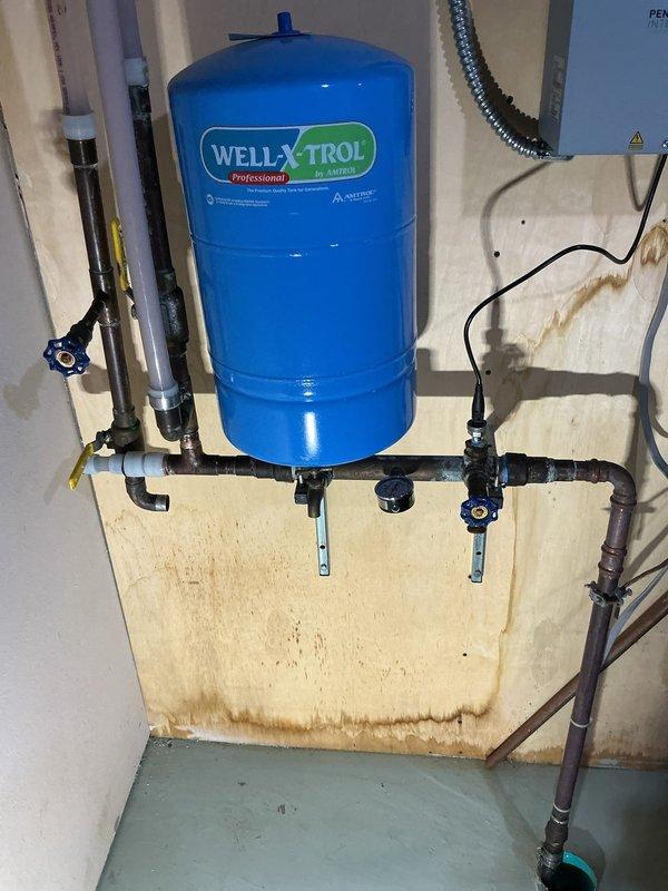 Located and repaired a leak in the copper piping connected to the Well-X-Trol pressure tank in the basement. Observed significant oxidation and corrosion at pipe joints, with visible water damage on the surrounding plywood wall indicating ongoing seepage. Completed repair of the compromised copper pipe section to resolve the issue.