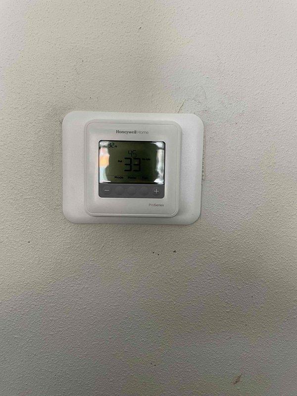 Diagnosed garage heater that was blowing cold air with non-responsive control panel. Corrected improperly installed batteries in thermostat which restored basic functionality. Found thermostat was malfunctioning and stuck at 40 degrees, installed new Honeywell ProSeries T4 thermostat after customer approval. Performed visual inspection of heat exchanger which showed no compromises. Verified proper system operation and instructed customer on thermostat use.