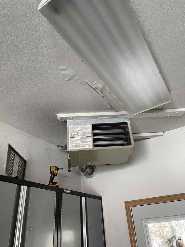 Diagnosed garage heater that was blowing cold air with non-responsive control panel. Corrected improperly installed batteries in thermostat which restored basic functionality. Found thermostat was malfunctioning and stuck at 40 degrees, installed new Honeywell ProSeries T4 thermostat after customer approval. Performed visual inspection of heat exchanger which showed no compromises. Verified proper system operation and instructed customer on thermostat use.