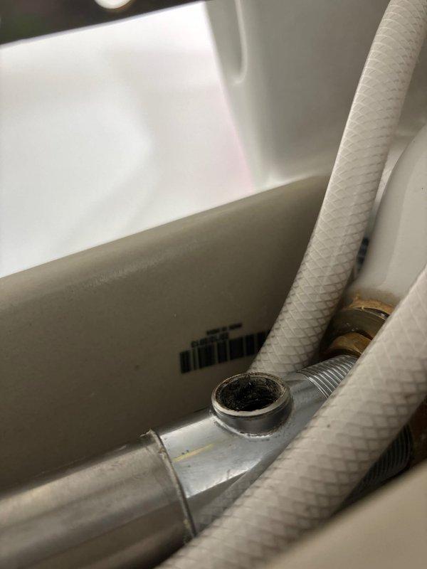 Replaced broken drain assembly in bathroom sink where pivot rod retaining nut had failed, causing stopper operation issues. Removed damaged components and installed new drain assembly, restoring proper functionality of the sink drain stopper mechanism.