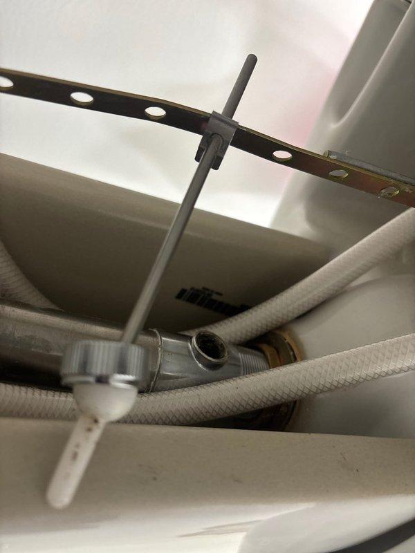 Replaced broken drain assembly in bathroom sink where pivot rod retaining nut had failed, causing stopper operation issues. Removed damaged components and installed new drain assembly, restoring proper functionality of the sink drain stopper mechanism.