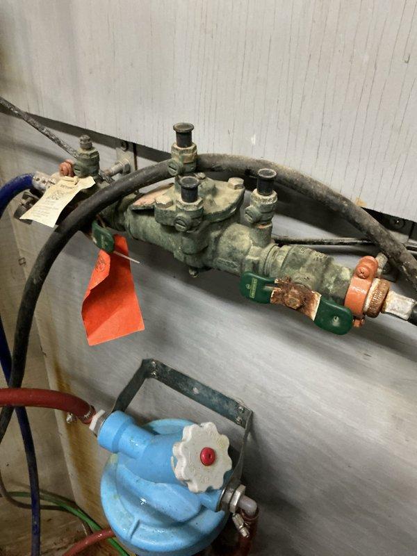 Responded to service call for RPZ valve failure in parlour area near compressors. Upon inspection, determined that the backflow prevention device was not maintaining proper pressure through the system. Identified need for complete rebuild kit due to internal component deterioration and corrosion evident on valve assembly. Left site with recommendation for RPZ rebuild to restore proper functionality.