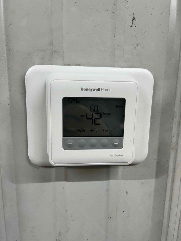 Diagnosed unit heater in shed not receiving call for heat signal. Jumped connection at board to verify furnace functionality. Installed new T4 Honeywell ProSeries thermostat to replace old non-functioning model. Verified proper system operation after installation. Also identified steam humidifier in main house requiring canister replacement; obtained customer approval to order replacement part.