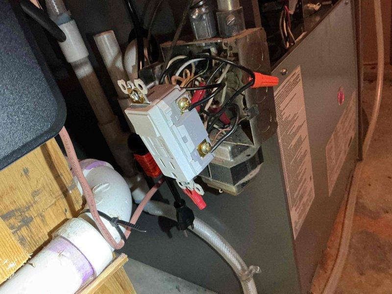 Responded to warranty call for newly installed furnace with no heat due to repeatedly tripping GFCI. Upon investigation, identified a stray cut wire with exposed copper bundled with hot wires, making contact with switch box. Removed the compromised wire, resolving the tripping issue and restoring normal system operation. Noted exposed switch poses potential safety hazard; recommended customer contact licensed electrician for proper repair.