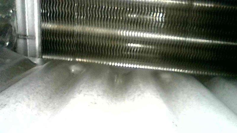 Performed scheduled furnace tune-up on 9-year-old Carrier system. Inspected all components which were operating properly. Identified water leak from humidifier; advised homeowner to replace water panel to resolve the issue. Documentation includes photos of ductwork with inspection ports and evaporator coil with notable frost accumulation.