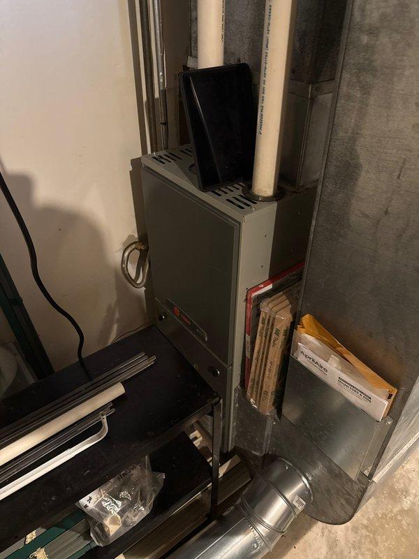 Performed routine tune-up on 15-year-old Trane furnace, confirming system is currently burning safely. Noted concerning condition of heat exchanger requiring monitoring and loud inducer motor posing reliability risk; documented visible water damage near system. Recommended customer obtain quotation for replacement system due to age and condition issues.
