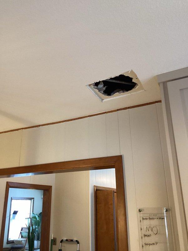 Inspected water leak reported through ceiling. Cut access opening to investigate source, finding no active leakage after water was restored. Identified low boiler pressure (5 psi) as possible contributor; recharged system to 20 psi. Monitored for one hour with water restored to confirm resolution. Potential cause may be ice dam related; no ongoing leakage observed during service period.