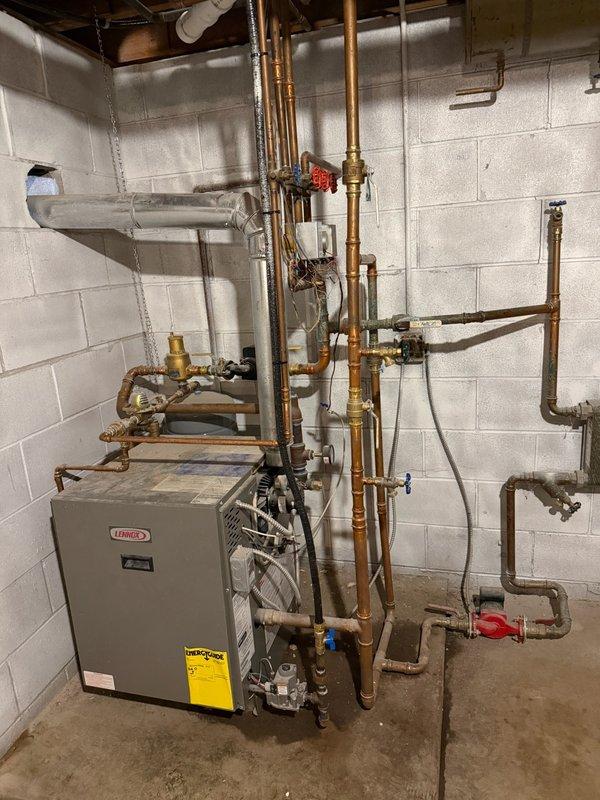 Diagnosed boiler system experiencing insufficient circulation due to air-lock condition. Removed and replaced a section of 1" copper piping as requested by homeowner. Performed system purge to eliminate air entrapment, thawed a blocked baseboard loop restricting flow, and restored normal circulation. Established proper water pressure at 20 psi, verified burner operation and gas pressure. System returned to normal operation with supply and return lines heating correctly. Note: Third zone remains intentionally shut as homeowners are aware and currently remodeling that area.