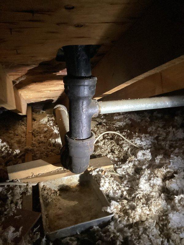 Responded to emergency ceiling leak in bedroom caused by deteriorated cast iron 90-degree fitting. Upon inspection in crawlspace, identified severe corrosion on cast iron pipe junction with active drip. Installed temporary drain pan to capture leakage and prevent further ceiling damage. Provided customer with estimate for complete replacement of the compromised cast iron section.