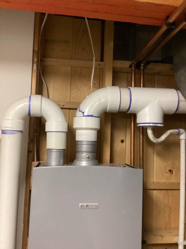 Performed diagnostic assessment on Bosch tankless water heater experiencing insufficient heating capacity for tub applications while maintaining adequate temperature (126°F) for sink fixtures. Completed comprehensive inspection of intake/venting system, ignitor, flame sensor, burner assembly, and heat exchangers, identifying heat exchanger scale buildup and control board errors. System exhibited shutdown issues following flush procedure. Scheduled follow-up service with technician Jared and arranged for comfort advisor to present repair/replacement options.