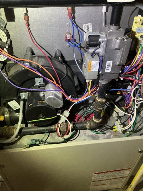 Diagnosed 11-year-old Tappan furnace with no heat condition despite thermostat indicating operation. Found reversed polarity code on initial inspection; after system reset, determined igniter had failed. Replaced igniter which restored proper ignition sequence as evidenced by normal blue flame pattern in burner assembly.