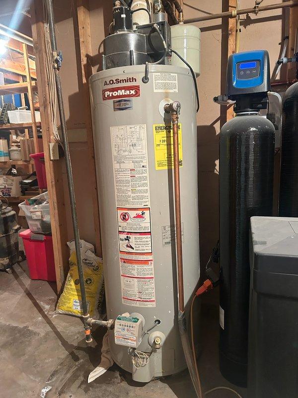 Responded to service call for a leaking Bradford White 50-gallon natural gas water heater, approximately 10 years old. Diagnostic inspection revealed a pinhole leak on the bottom skirt of the tank, requiring full unit replacement. Successfully installed new A.O. Smith ProMax water heater with proper connections to existing water lines and gas supply.