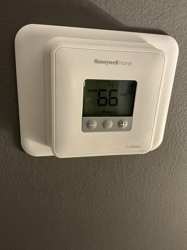 Responded to no heat complaint for aging fan coil boiler system. Upon inspection, determined that all components are functioning correctly, but unit is unable to maintain desired temperature (currently reading 66°F) due to poor thermal envelope. Identified that supply vents are positioned adjacent to drafty window and glass sliding door, causing significant cold air infiltration that reduces heating efficiency. Advised customer that system limitations cannot be overcome without addressing building envelope issues.